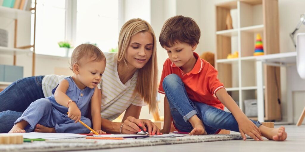 A babysitter is teaching children how to draw | Babysitter Service