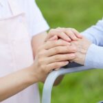 Private caregiver gently holding the hand of a patient, offering comfort and compassionate support.
